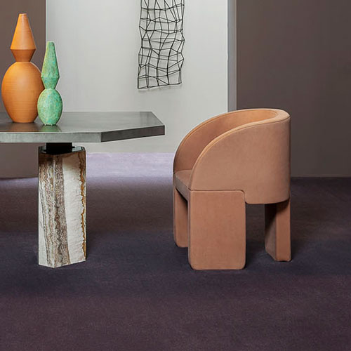Armchair made of three-legged base with velvet fabric in an orange tone in a living room