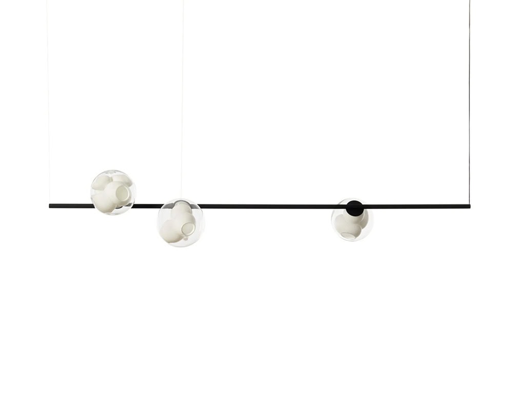 Boc Stem Suspended Ceiling Light features three white ceramic cluster orbs inside glass spheres, suspended along a matte black horizontal stem. The clean white background highlights the fixture's sculptural and balanced composition.