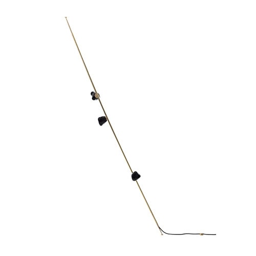 Boc Stem Column Floor Light stands tall and poised, featuring hand-blown black glass clusters arranged along a sleek brass rod. The tilted composition enhances its sculptural presence while providing dramatic ambient lighting.