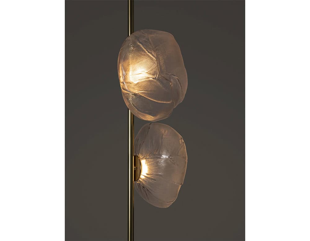 Detail of the hand-blown glass orbs softly illuminated from within, mounted on a slim metallic stem. The organic texture and glow highlight the artisan craftsmanship and atmospheric quality of the fixture.
