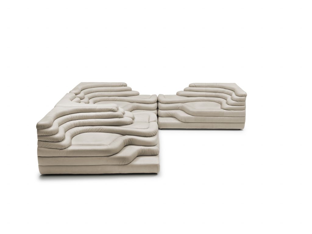 Three white cream DS Thousand twenty five sofa elements. The single element is a terraced hill with widths and depths that vary in tapering steps on a white background.