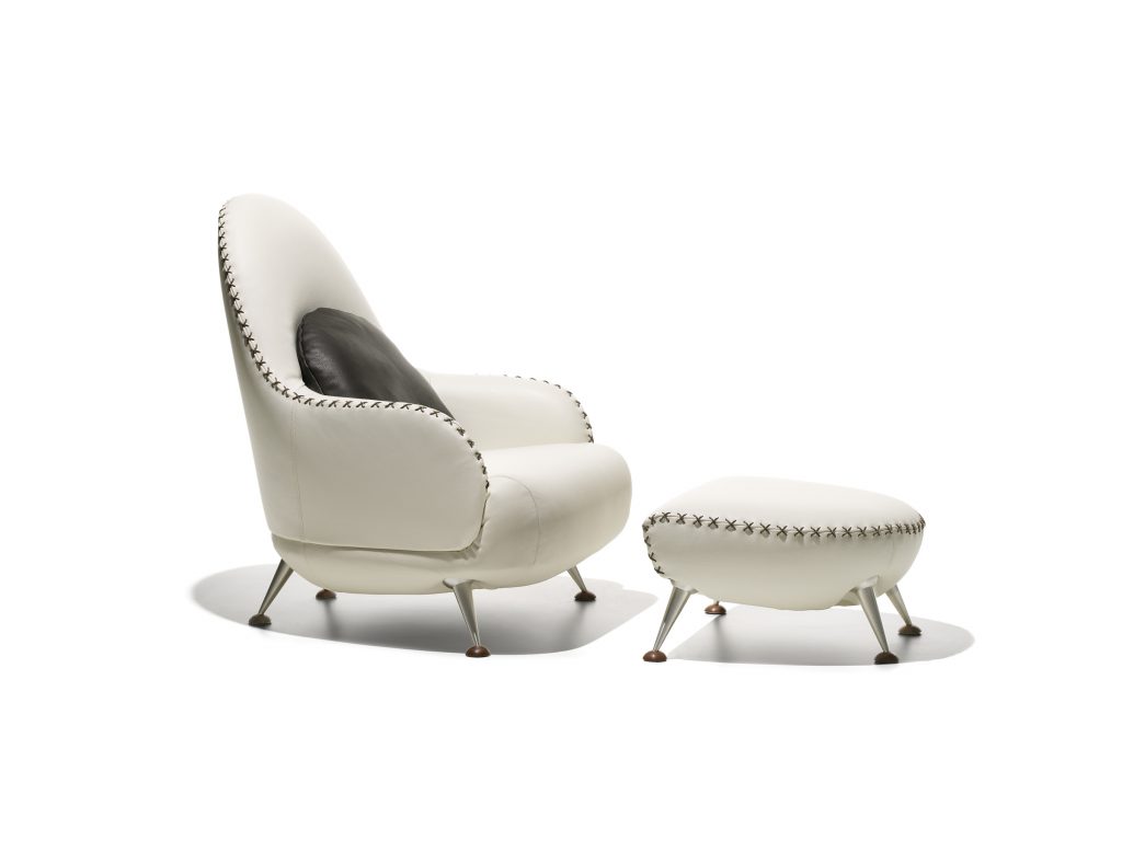 DS hundred two- eleven armchair with footstool. White and black upholstered shell on a white background.