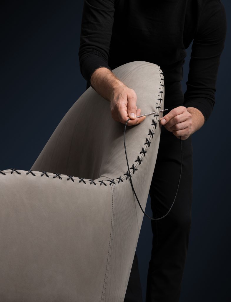 DS hundred two- eleven armchair. Grey and black upholstered shell on a black background.