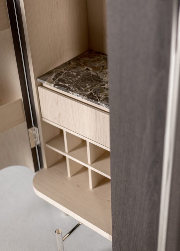 vertical furniture made of a wooden, glass and steel base with internal drawers on a white background