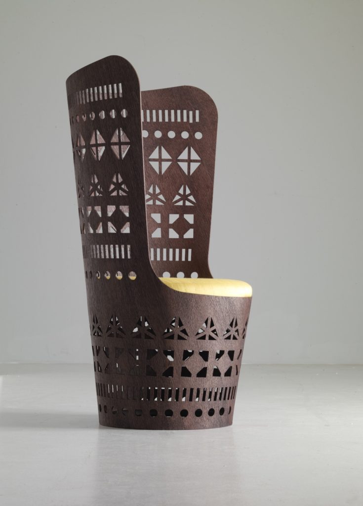 armchair made from a flexible sheet and wood base with a fretwork design and cushion in a yellow and brown colour tone