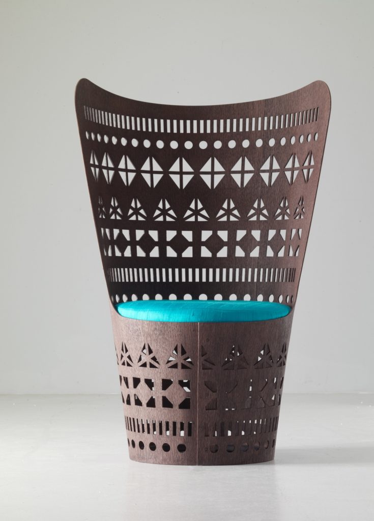 armchair made from a flexible sheet and wood base with a fretwork design and cushion in a blue and brown colour tone