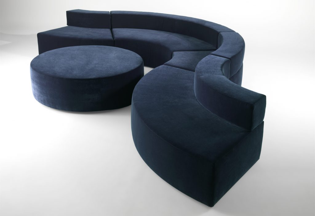 modular sofa made on a wooden base and covered in a blue snake-shaped fabric on a white background