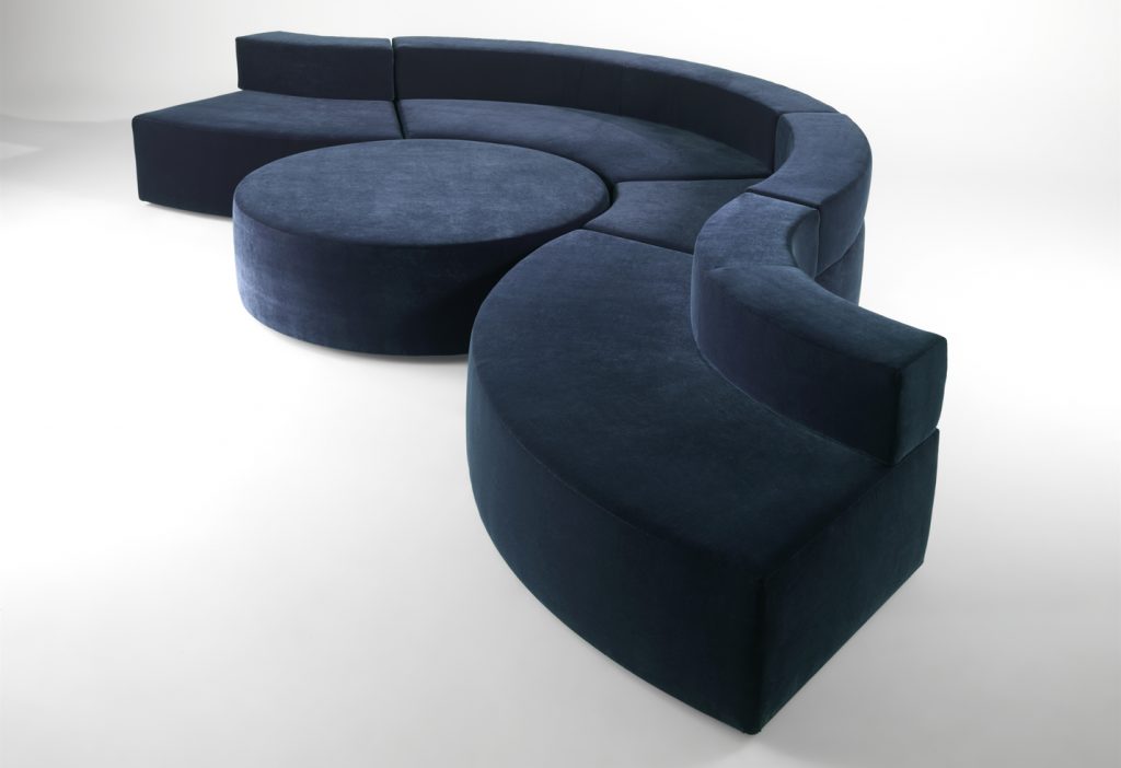 modular sofa made on a wooden base and covered in a blue snake-shaped fabric on a white background