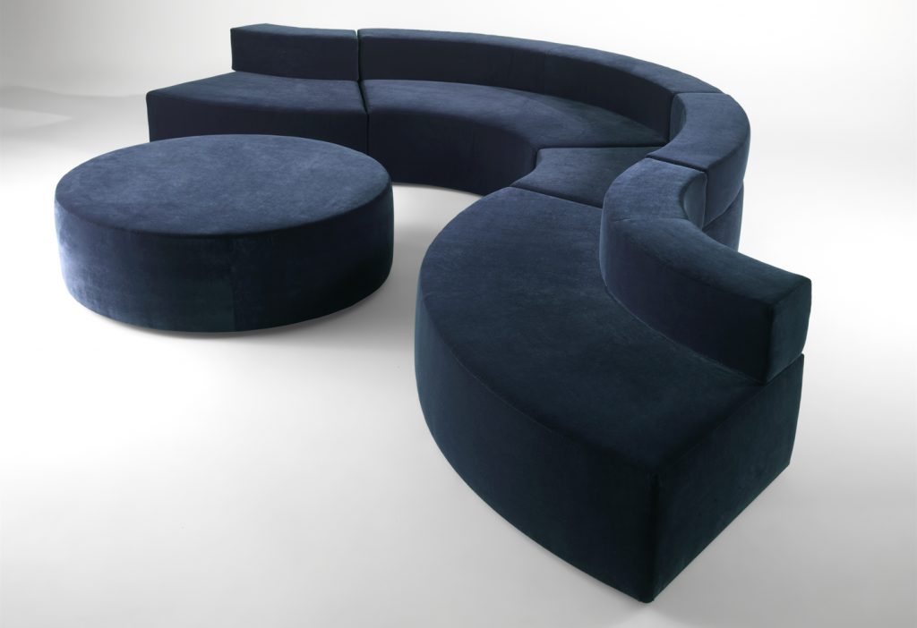 modular sofa made on a wooden base and covered in a blue snake-shaped fabric on a white background