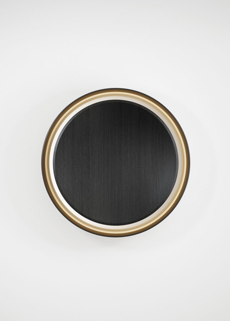 round mirror made of a wooden base covered in polished metal in a black and gold colour tone
