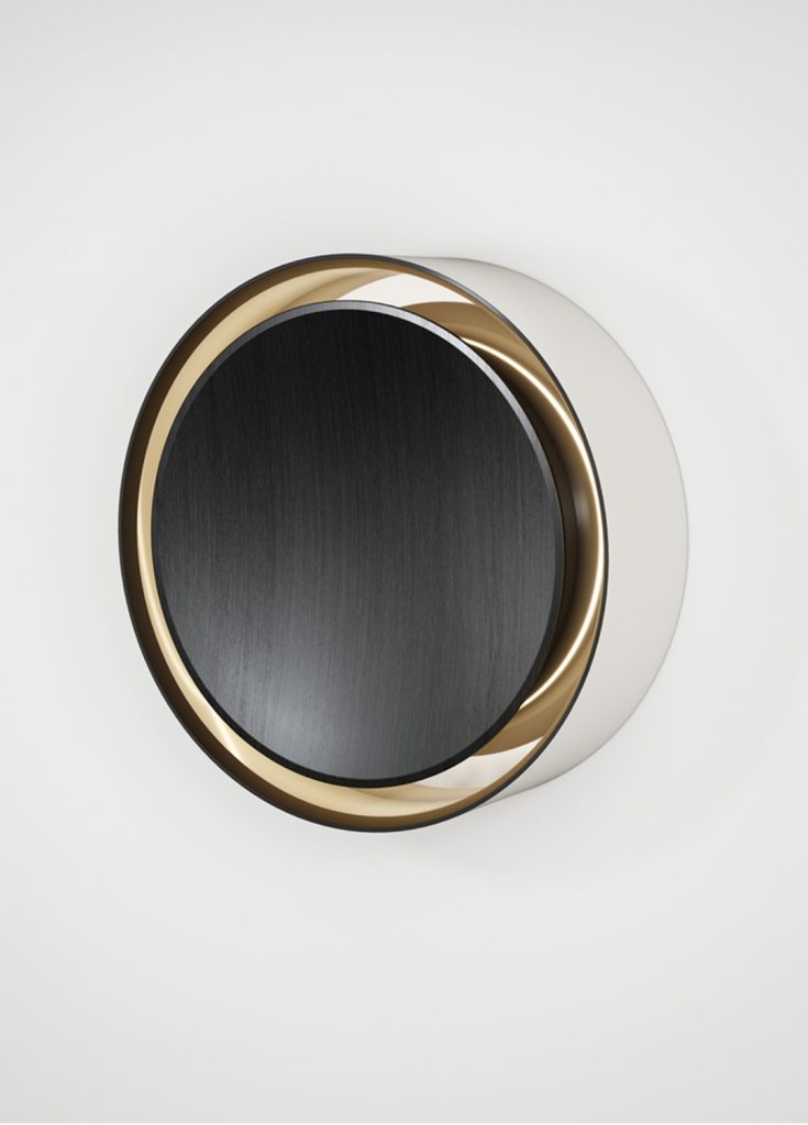 round mirror made of a wooden base covered in polished metal in a black and gold colour tone