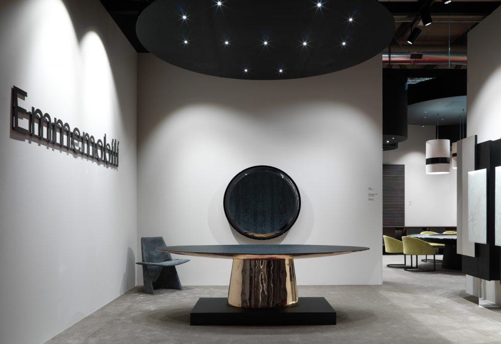 round mirror made of a wooden base covered in polished metal in a black colour tone in a living room