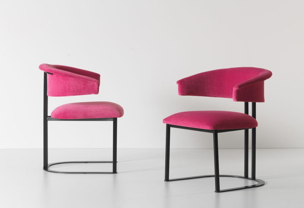 two curved armchairs made of an iron brass base and pink leather
