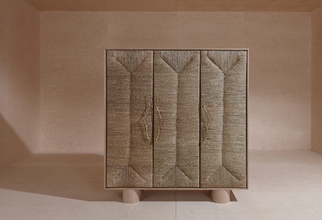 storage furniture made of veneered wood panels and covered with straw in a beige color tone