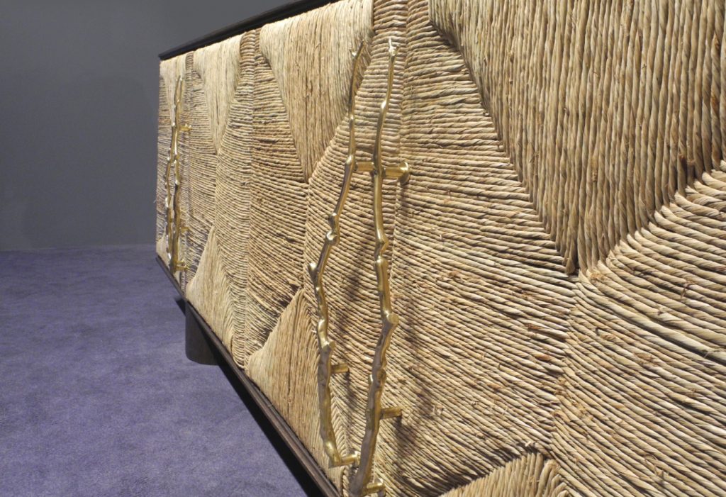 sideboard made of a wooden base covered with straw in a beige tone on a blue room