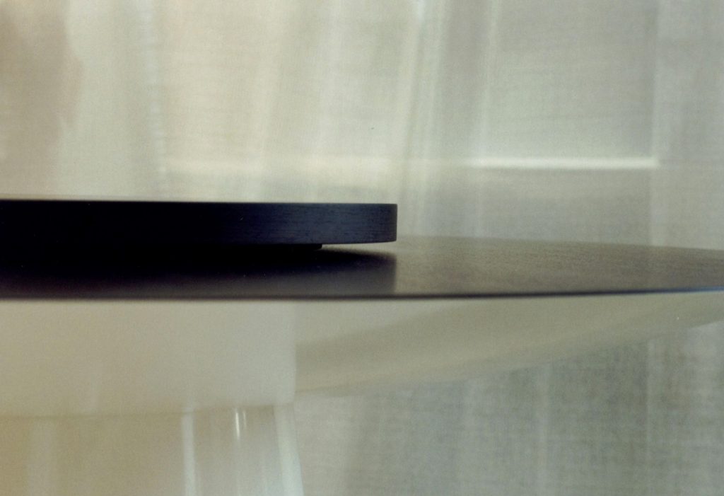 circular table made of a glass and wood base in a black colour tone