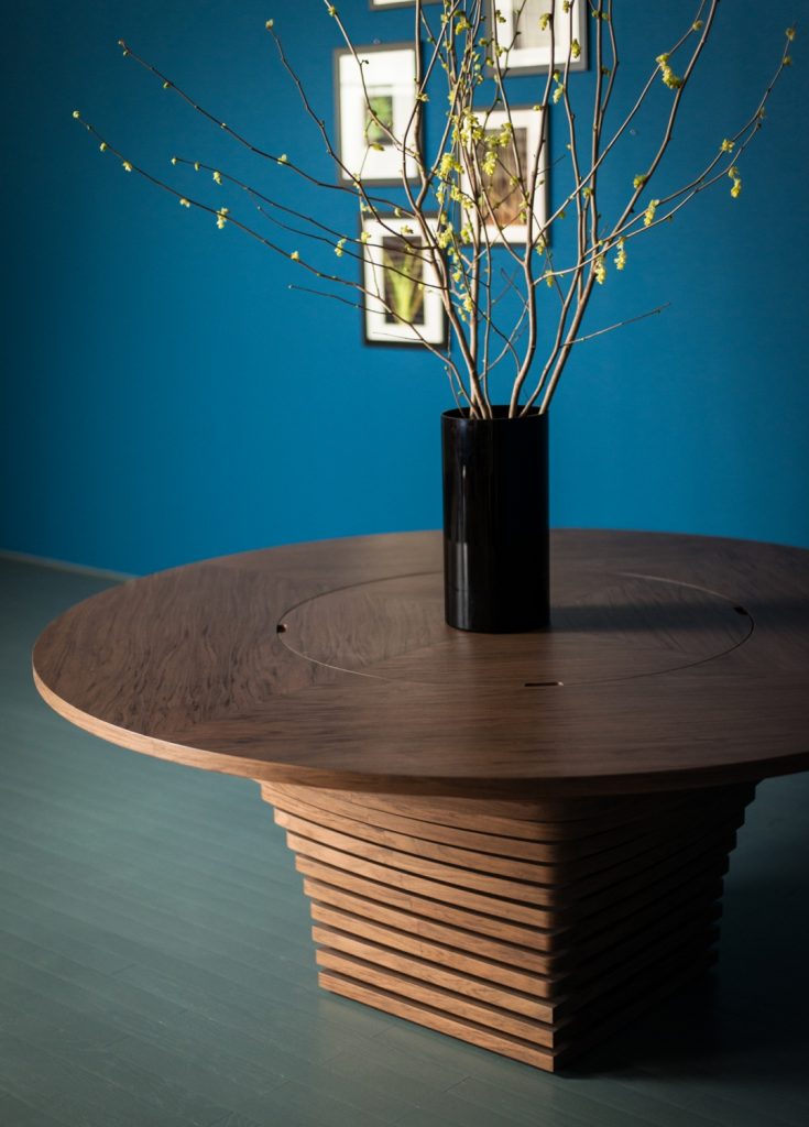 circular table made of a wooden and glass base in a brown colour tone in a living room