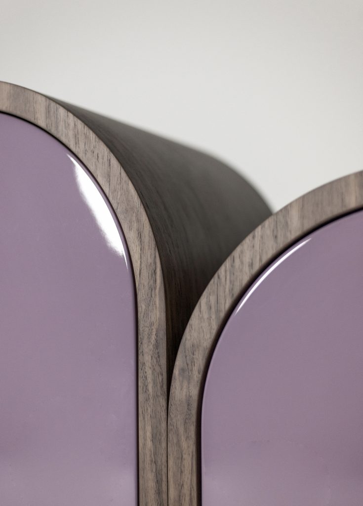 rounded-shaped storage furniture made of a wooden base in a golden and pinkish tone on a white background