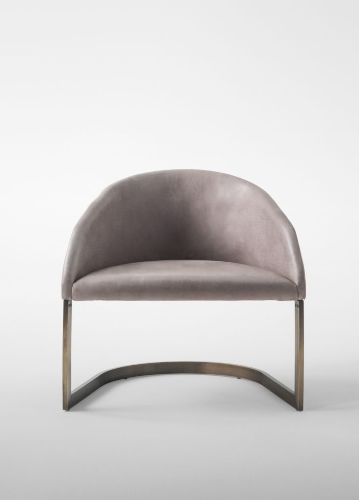 Low armchair made of a steel base and upholstered in velvet fabric in a beige colour tone