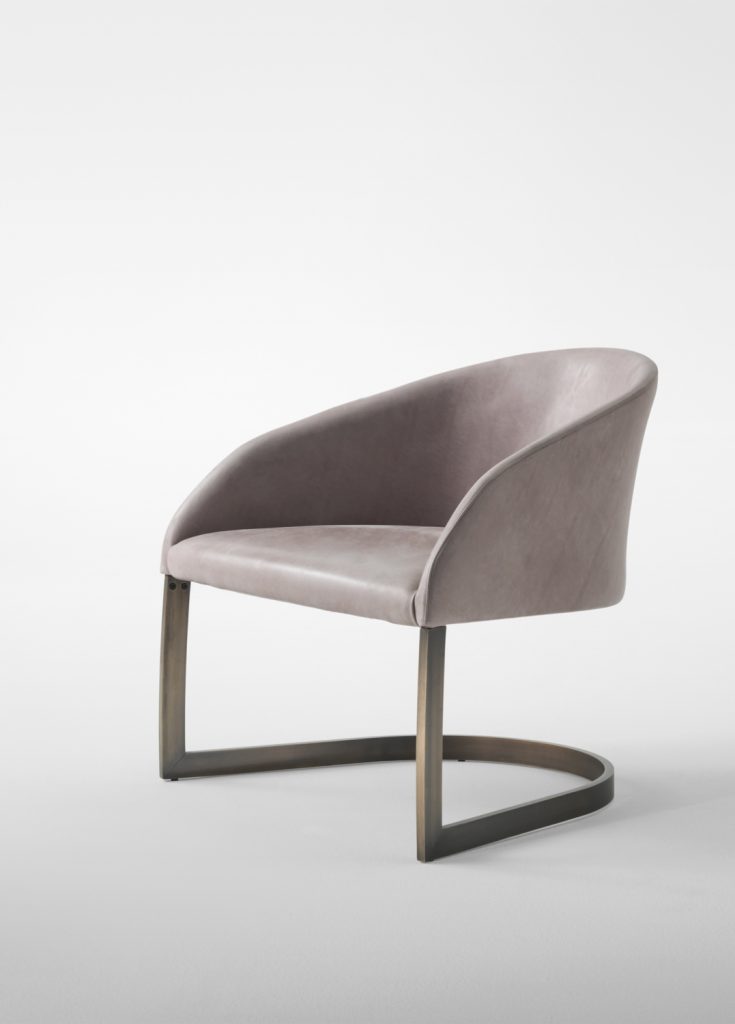 Low armchair made of a steel base and upholstered in velvet fabric in a beige colour tone