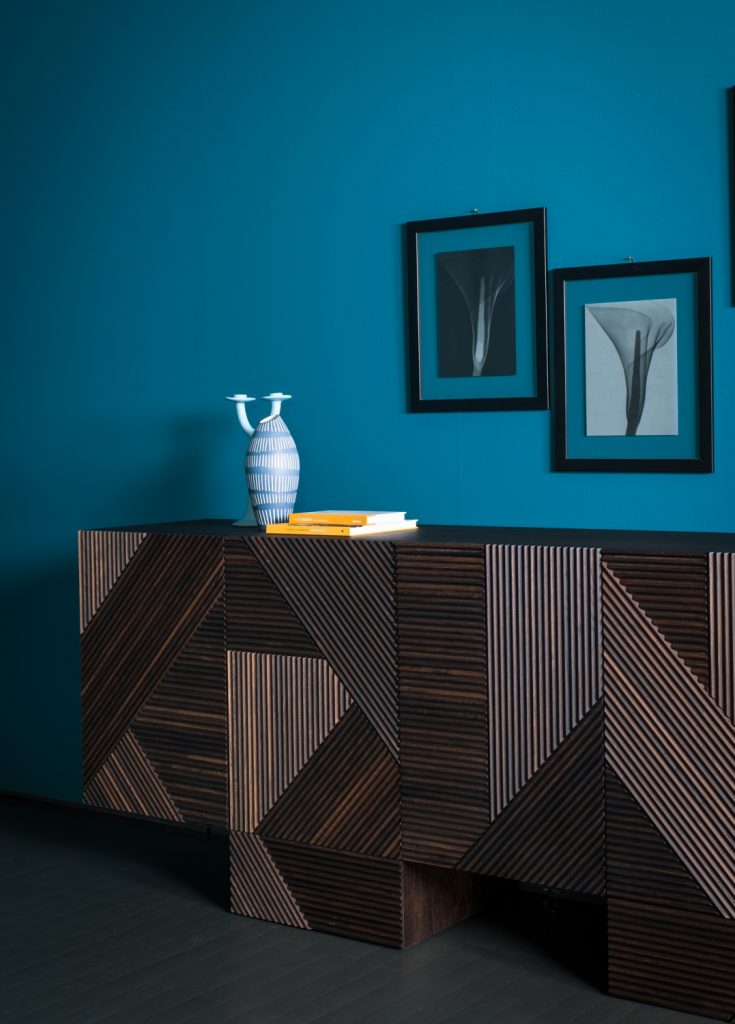 Closeup of Stripes Cabinet: Large cabinet with brown vertical striped pattern and multiple drawers in front of a blue wall.