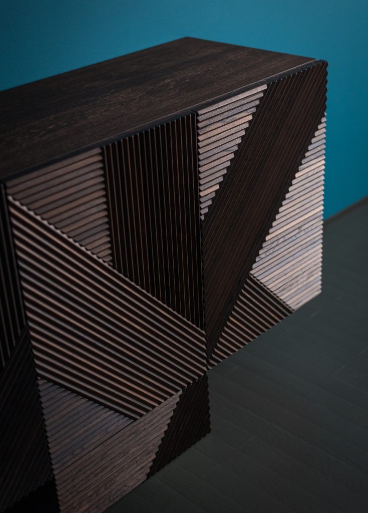 Closeup of Stripes Cabinet: Large cabinet with brown vertical striped pattern and multiple drawers in front of a blue wall.