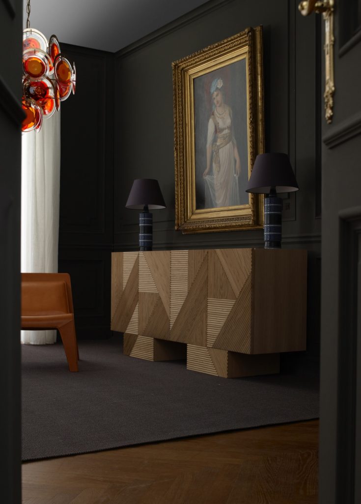 Closeup of Stripes Cabinet: Large cabinet with brown vertical striped pattern and multiple drawers in front of a black wall.