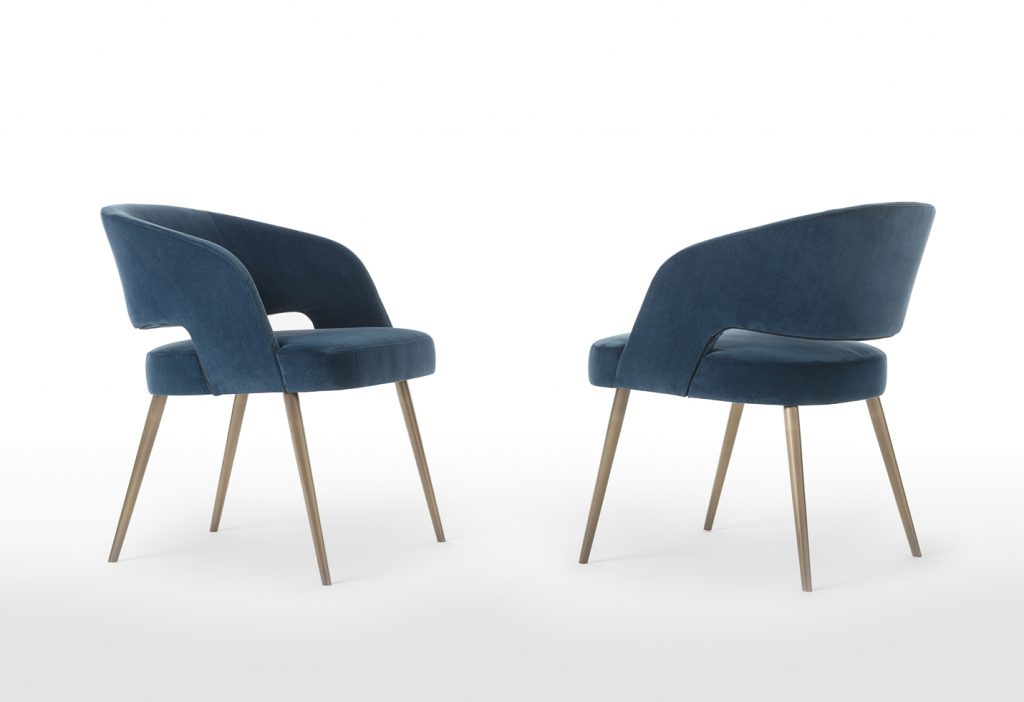 Two armchairs made of a wood and metal base upholstered in leather in a blue tone on a white background