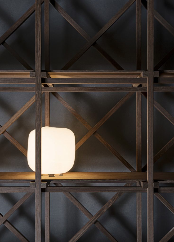 shelf made of solid wood beams in a brown tone with a lamp on it