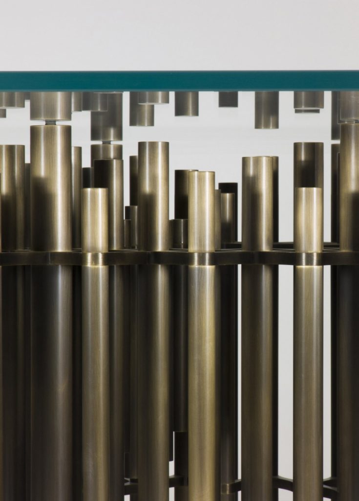 dining table made on a base of brass tubes and transparent glass top in a golden color