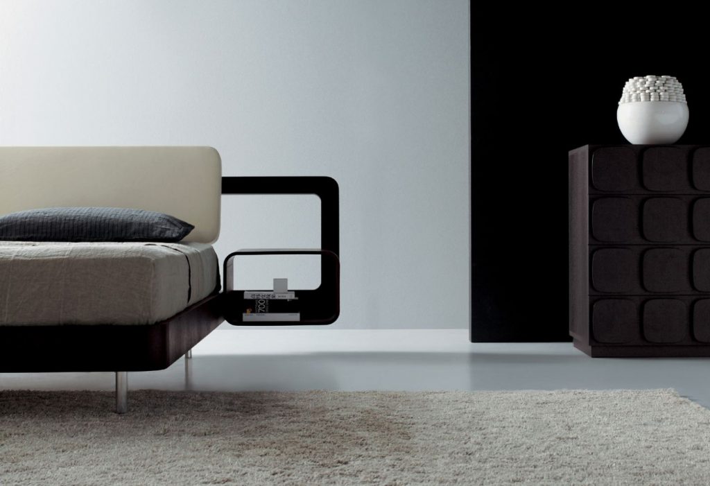 Double bed made of a wooden base padded with leather in a white and brown colour tone.