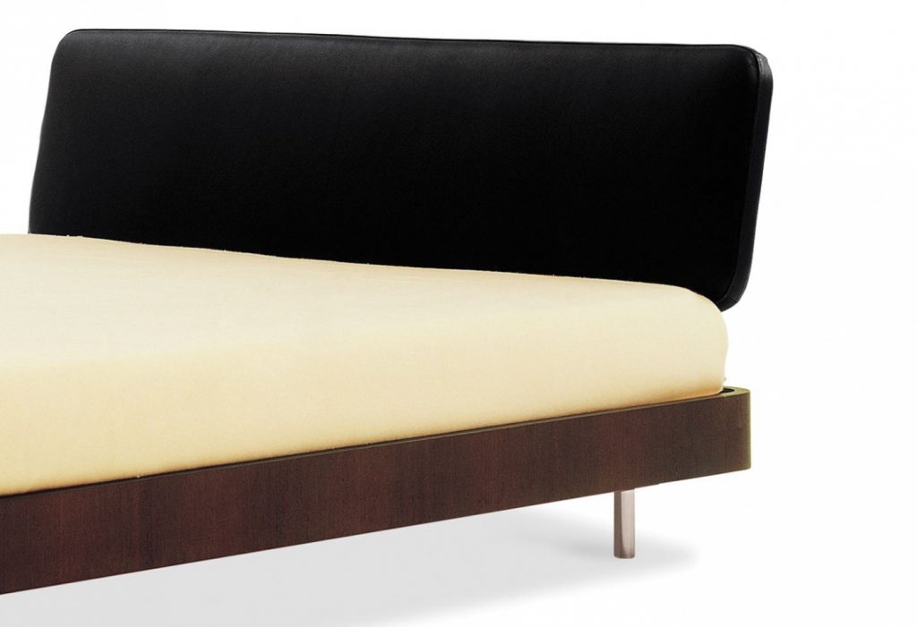 Bed made of a wooden base covered in leather in a white, black and brown colour tone on a white background