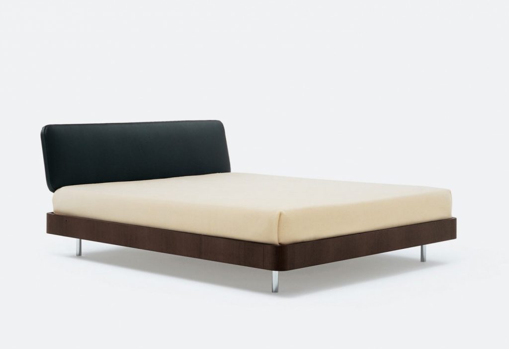 Bed made of a wooden base covered in leather in a white, black and brown colour tone on a white background