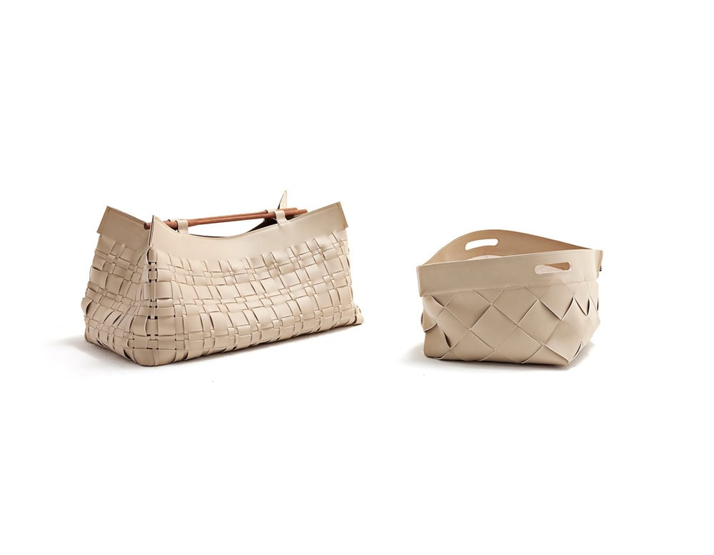 A studio shot of the 10th Baskets Tray collection featuring two variations with intricate woven leather designs structured forms and neutral tones