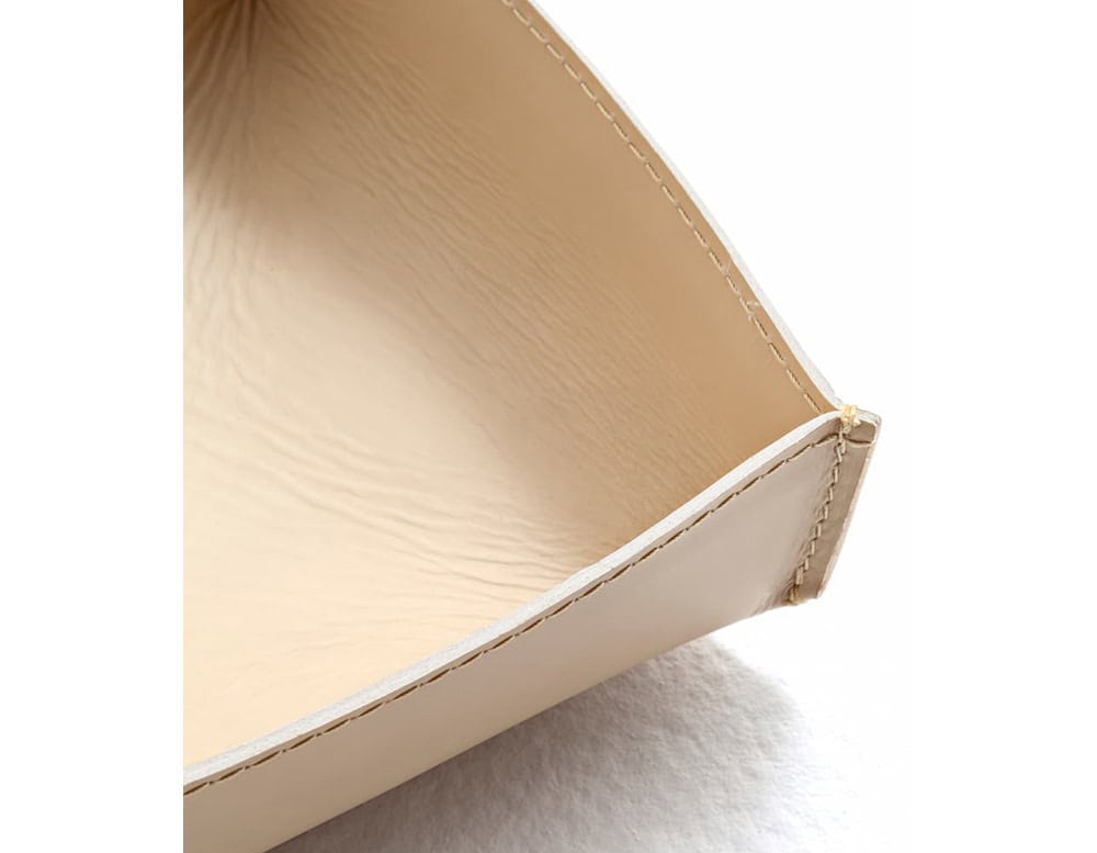 A detailed close-up of the 10th Baskets Tray showcasing its smooth leather interior precise stitching and gently curved structured edges