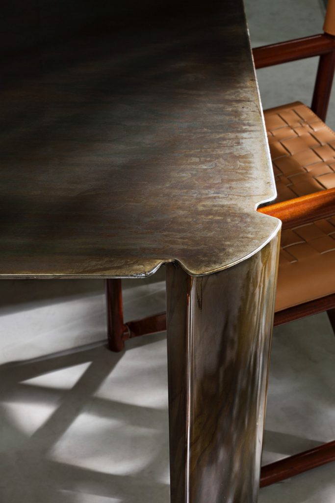 Closeup of 10th Bridge Table: Rectangular table with a wooden top and four legs on a terrace.