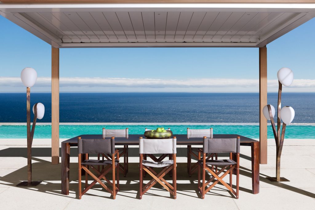 10th Bridge Table: Rectangular table with a wooden top and four legs on a terrace.
