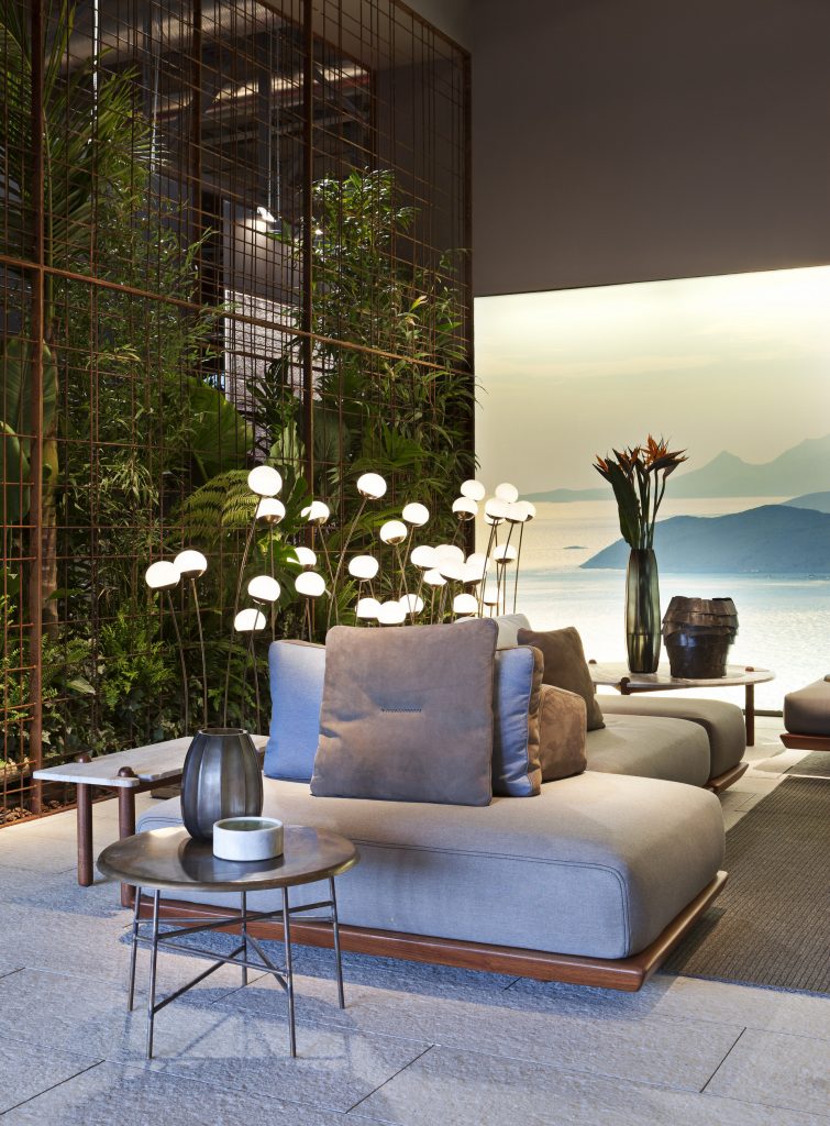 Caprera Island sofa. Upholstered in blue fabric, base in brown leather in a living room.