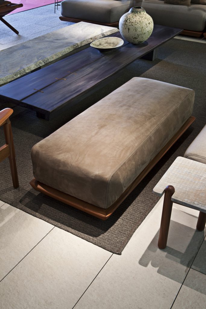 Caprera Island sofa. Upholstered in blue fabric, base in brown leather in a living room.