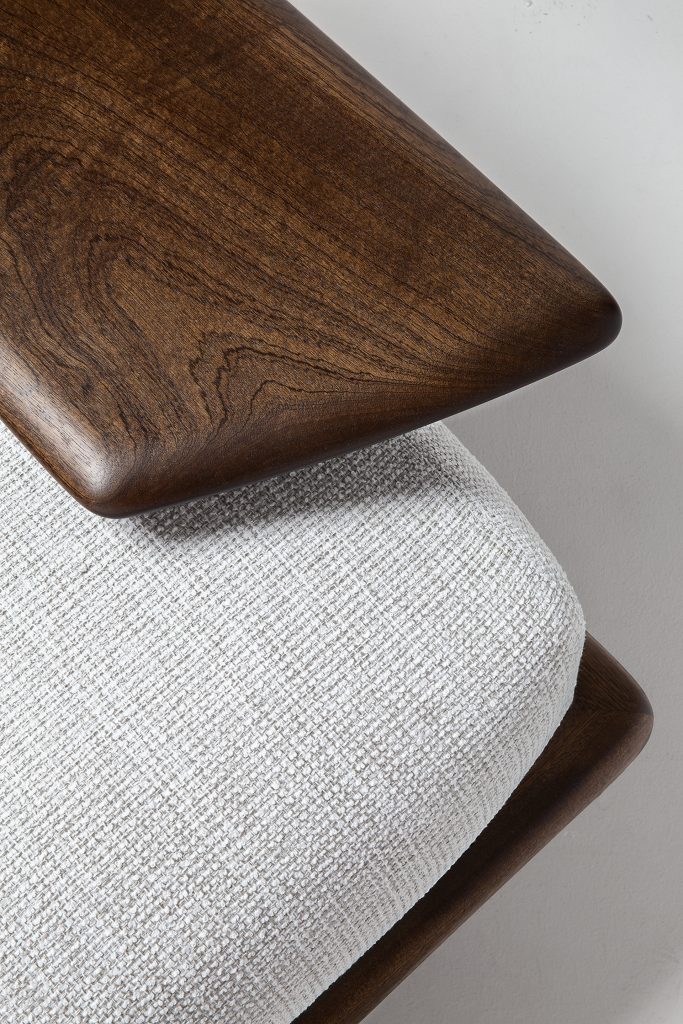 Closeup of Caprera Sofa: Large gray cushioned sofa with wooden frame and black legs on a white background.