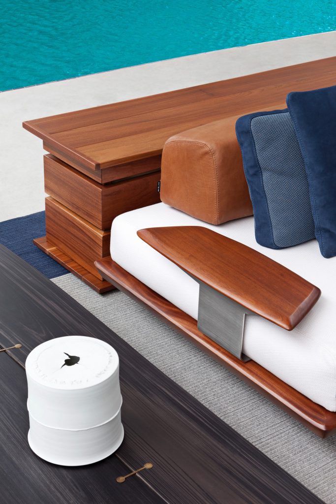 Closeup of Caprera Chest: Large wooden storage chest with two legs in a bedroom.