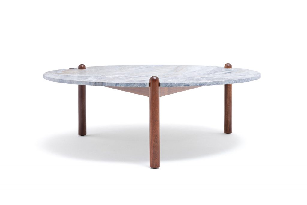 Caprera Coffee Table. White round top with three sleek brown legs on a white background.