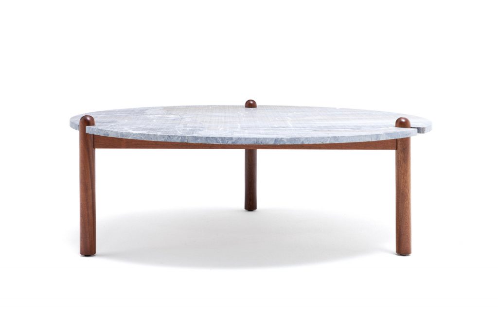 Caprera Coffee Table. White round top with three sleek brown legs on a white background.