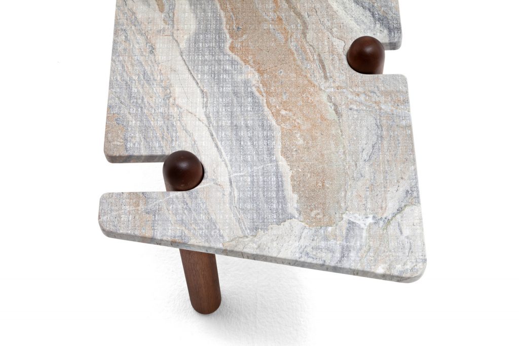 Closeup of Caprera Coffee Table. Gray stone square top with four sleek brown legs on a white background.