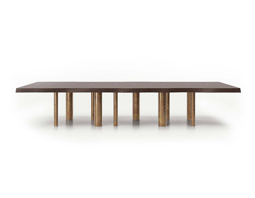 A 10th Joint Dining Table with a long, dark rectangular top and multiple cylindrical legs is shown against a white background