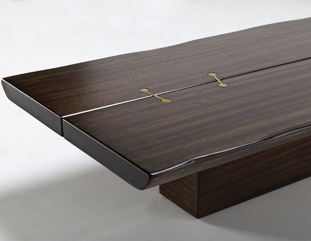 A 10th Joint Wood Coffee Table with a dark wood rectangular top and a unique joint detail is shown against a light background