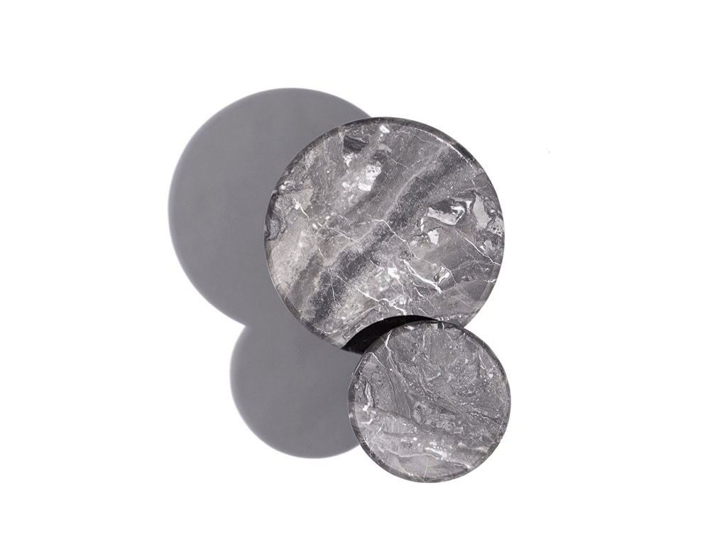 A 10th Star Coffee Table with a round, gray marble top and a dark metal base is shown with a matching 10th Star Coffee Table Stool; both pieces are set against a white background