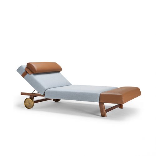 The 10th Sun Lounger with a light cushion, brown leather headrest and footrest, and a wood frame is shown at a distance on a white background