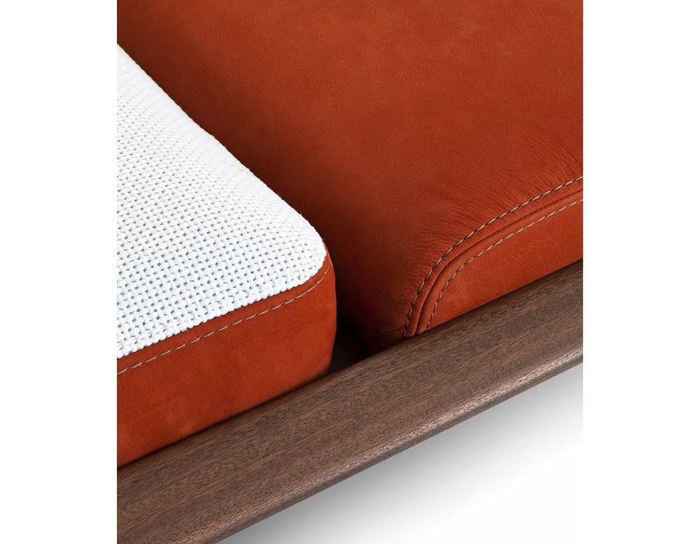A detailed close-up of the 10th Tellaro Sun Lounger showcasing its plush dual-tone cushions with rich terracotta and white fabric on a sleek wooden frame