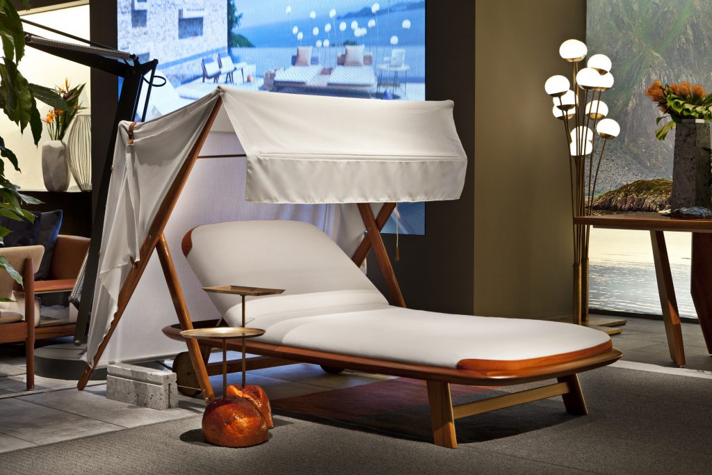10th Tellaro Sun Lounger: White cushioned sun lounger with an adjustable backrest and wooden frame in a showroom.